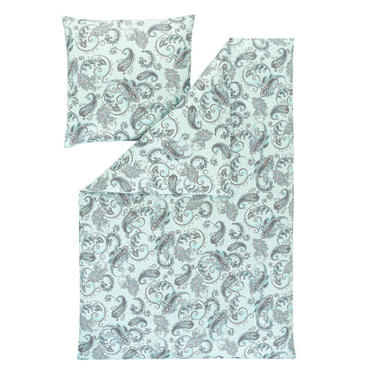 Ein Kopfkissen und eine Bettdecke bezogen mit Mako-Interlock-Jersey Bettwaesche mit einem Muster aus Ornamenten in der Farbe Blau. Modell Paisley hellblau.