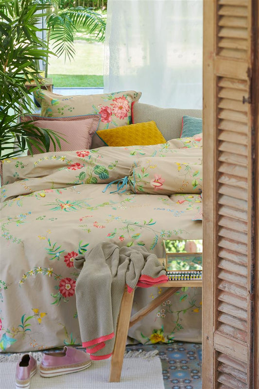 Auf einem Bett liegen mehrere Kopfkissen und eine Bettdecke bezogen mit Perkal-Baumwoll Bettwaesche aus 100 Prozent Baumwolle mit Muster aus Blumen in der Farbe Beige. Modell Fleur Grandeur Khaki.
