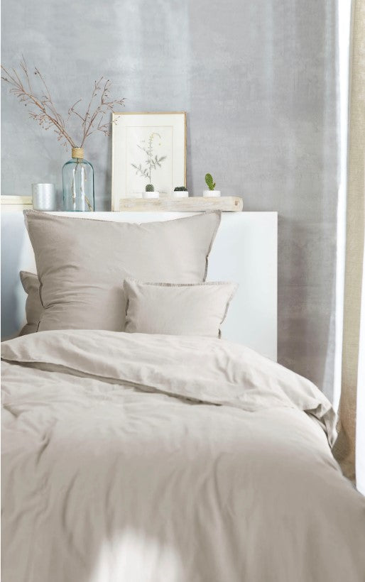 Ein Bettbezug-Set aus mehreren Kopfkissen und einer Bettdecke bezogen mit Renforce Bettwaesche aus 100 Prozent Baumwolle in der Farbe Beige. Modell Stone-Washed Sand 719.