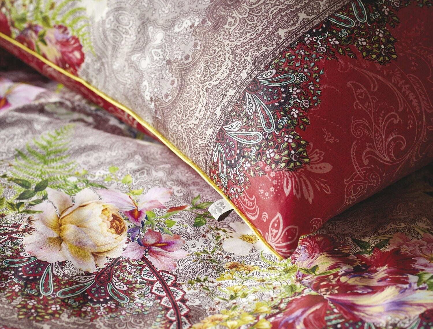 Detaildarstellung der Ornamenten auf Kopfkissen und Bettdecke der Satin Bettwaesche Modell Oriental Rot.