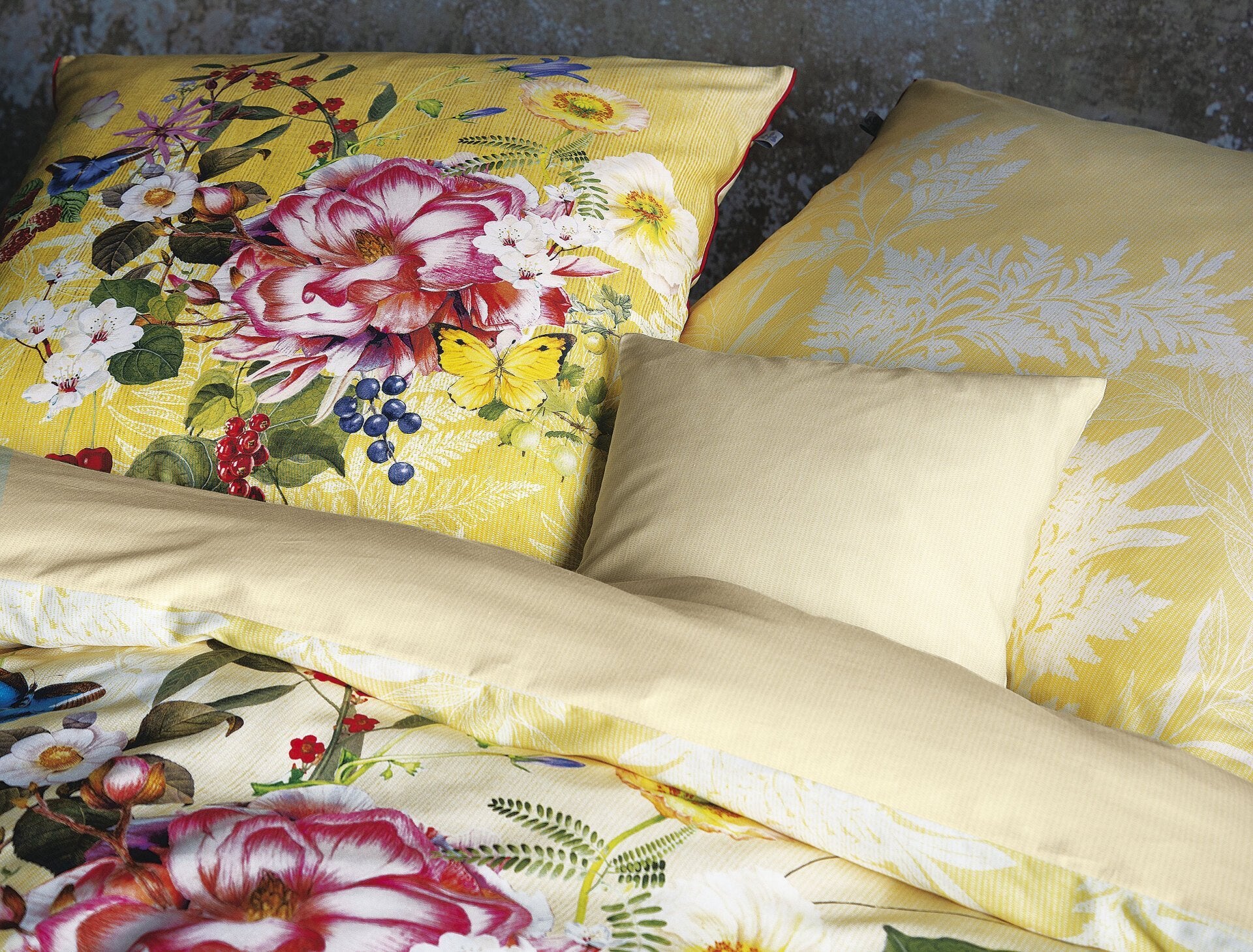 Detaildarstellung der Blumen auf Kopfkissen und Bettdecke der Satin Bettwaesche Modell Rose Gelb.