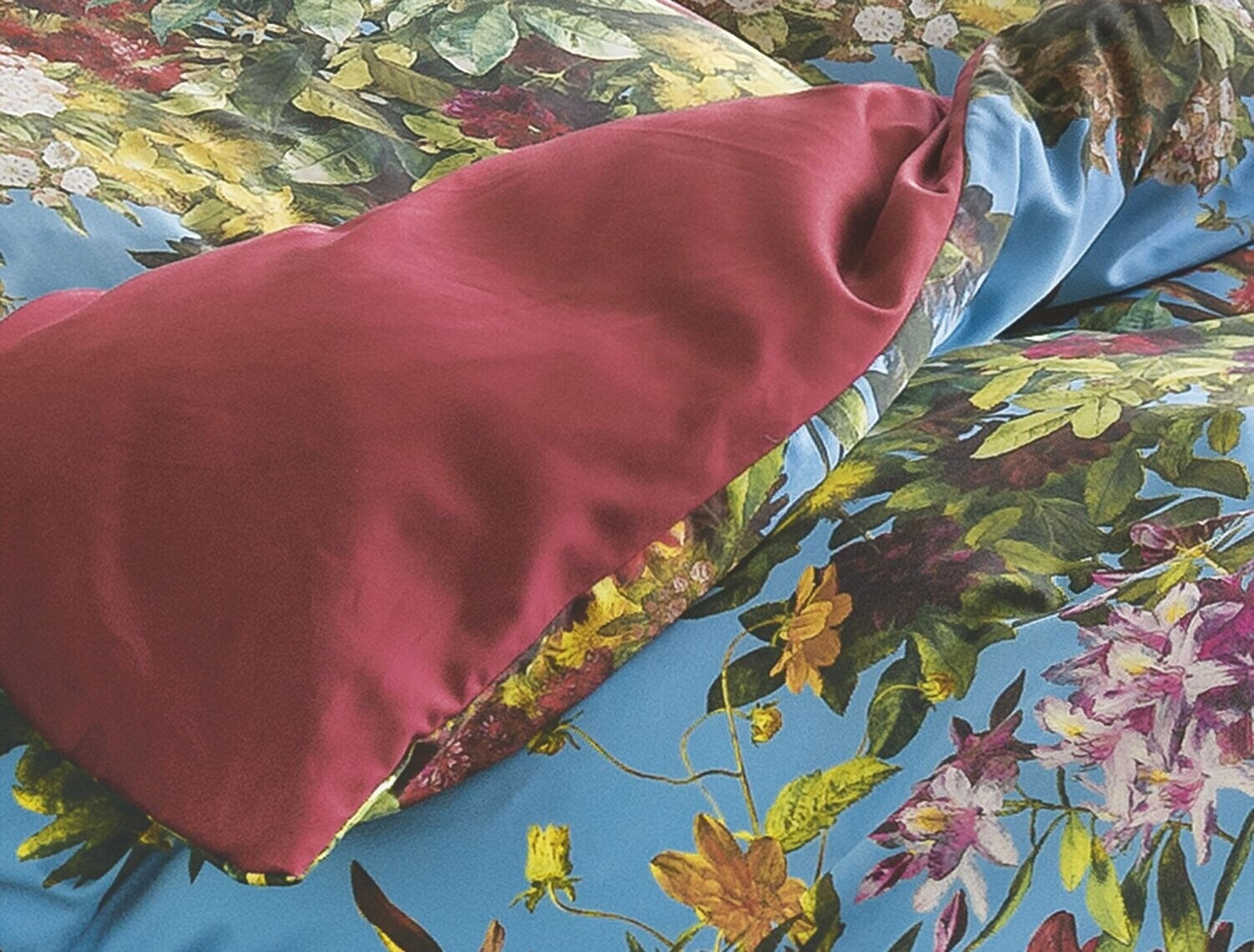 Detaildarstellung der Blumen auf Kopfkissen und Bettdecke der Satin Bettwaesche Modell Sommer Blau.